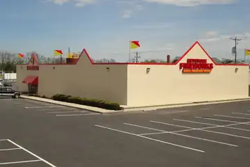 Keystone Lancaster building with red trim and a large parking lot
